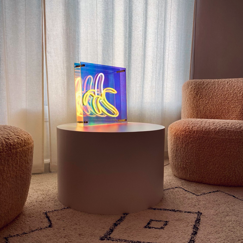A banana infinity mirror light on a side table in a living room